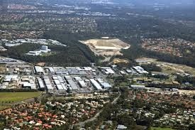 Aerial view of an urban area with residential neighborhoods, industrial buildings, and green spaces.