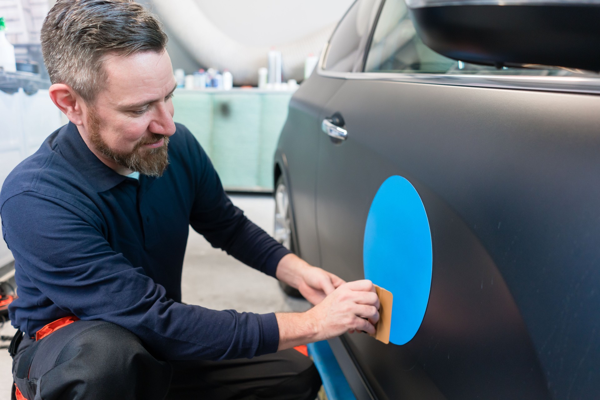 Man putting sticker with company slogan on a car