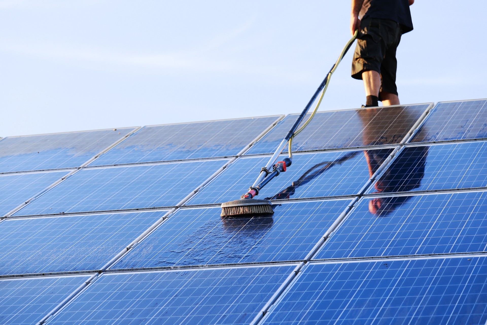 Cleaning solar panels with brush and water